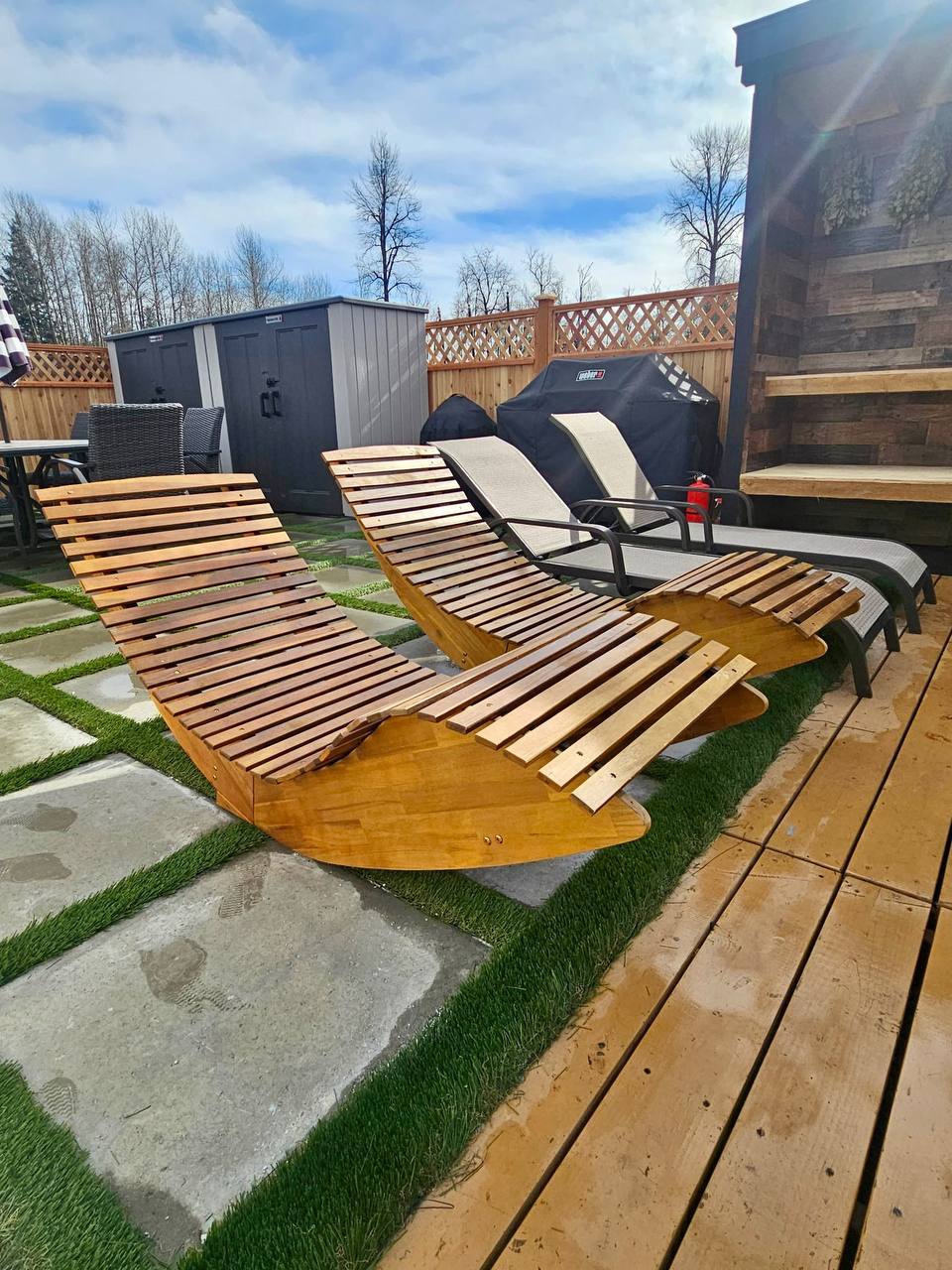 Wooden loungers and BBQ grill on the deck