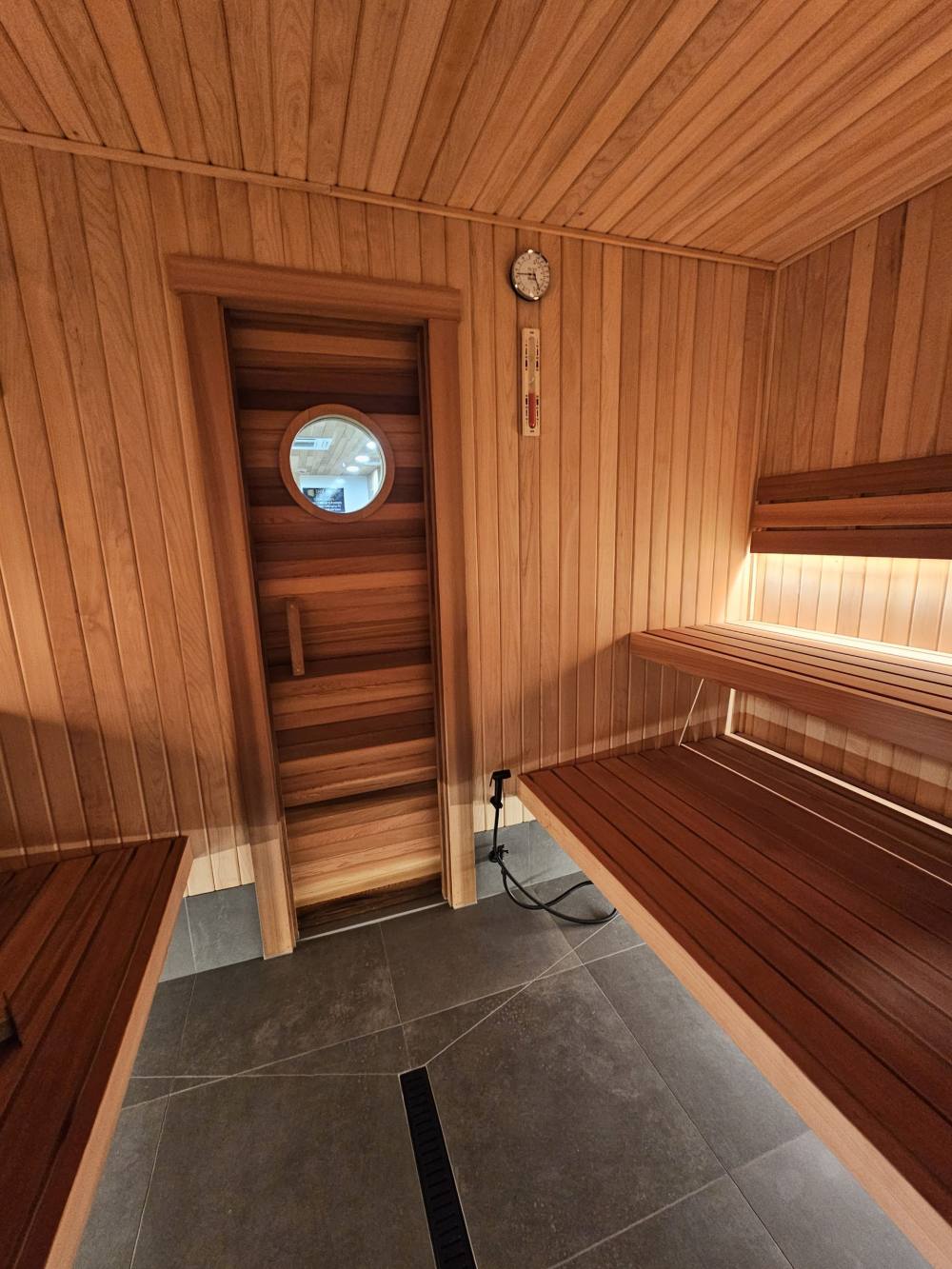 Cedar sauna room with warm lighting under the benches
