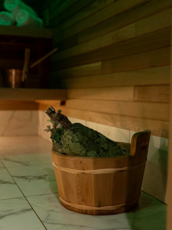 Cedar sauna with a venik in a wooden bucket