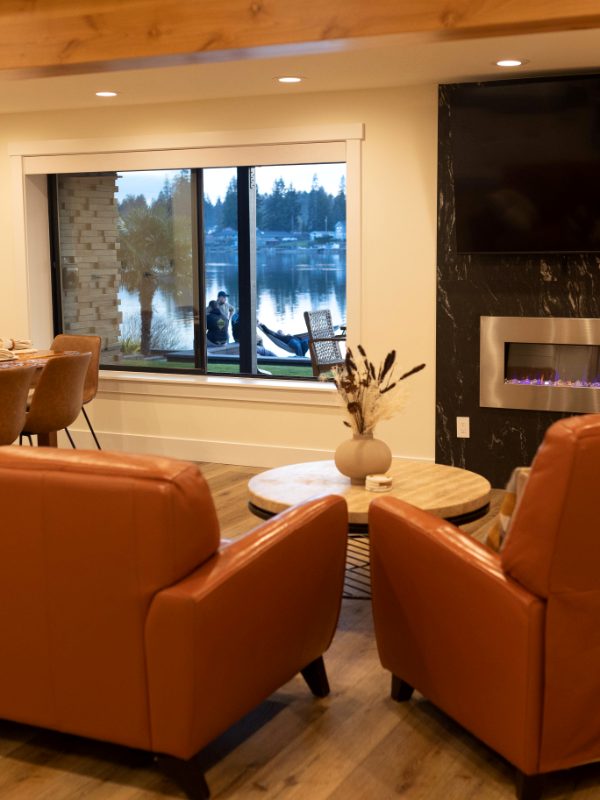 Leather armchairs, fireplace and a lake view through the window