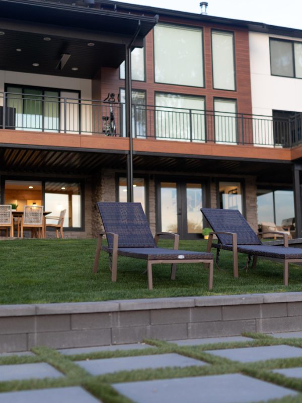 Lake house with a lawn, patio and lounge chairs