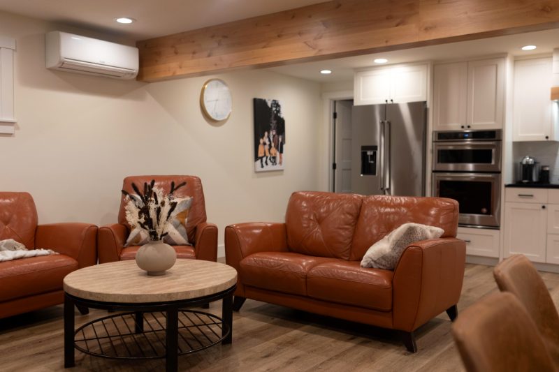Open lounge with leather sofas and a full kitchen