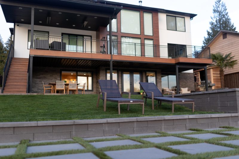 Lake house with a lawn, patio and lounge chairs