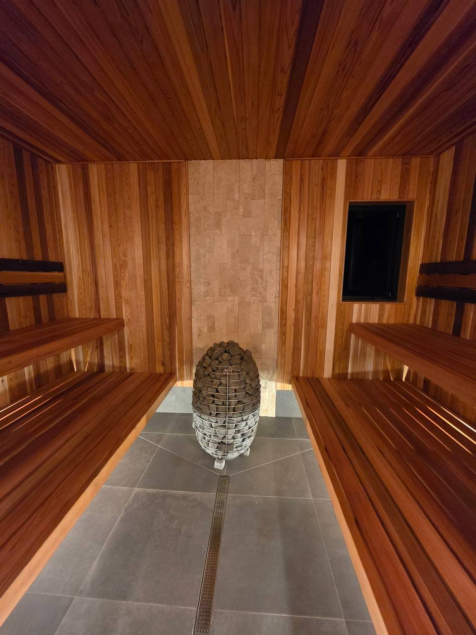 Cedar sauna with a stone heater in the center