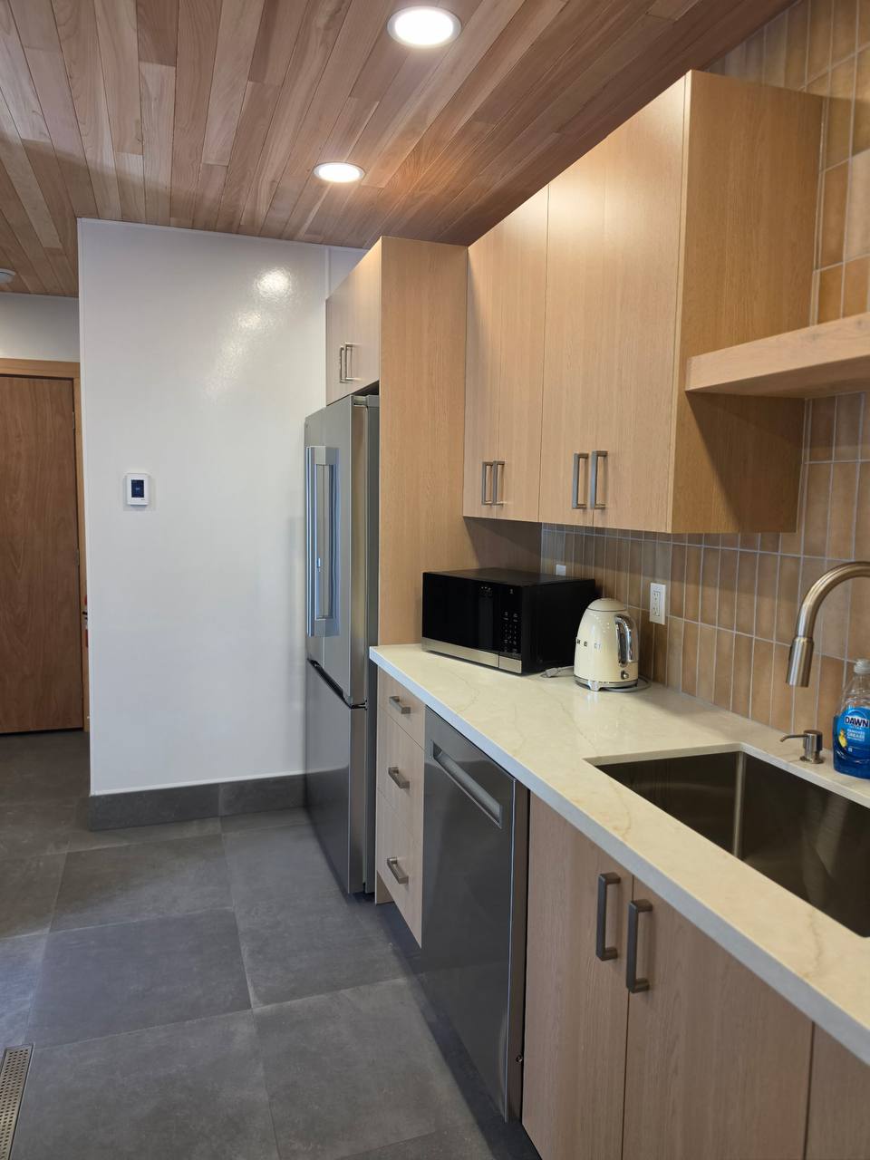 Kitchen with fridge, microwave and kettle