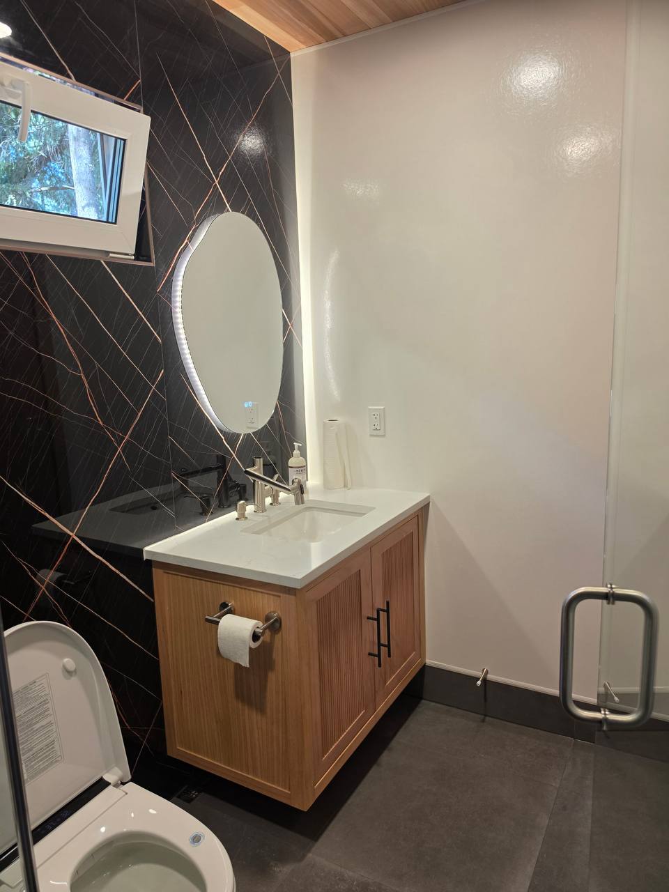 Wooden vanity with a backlit mirror