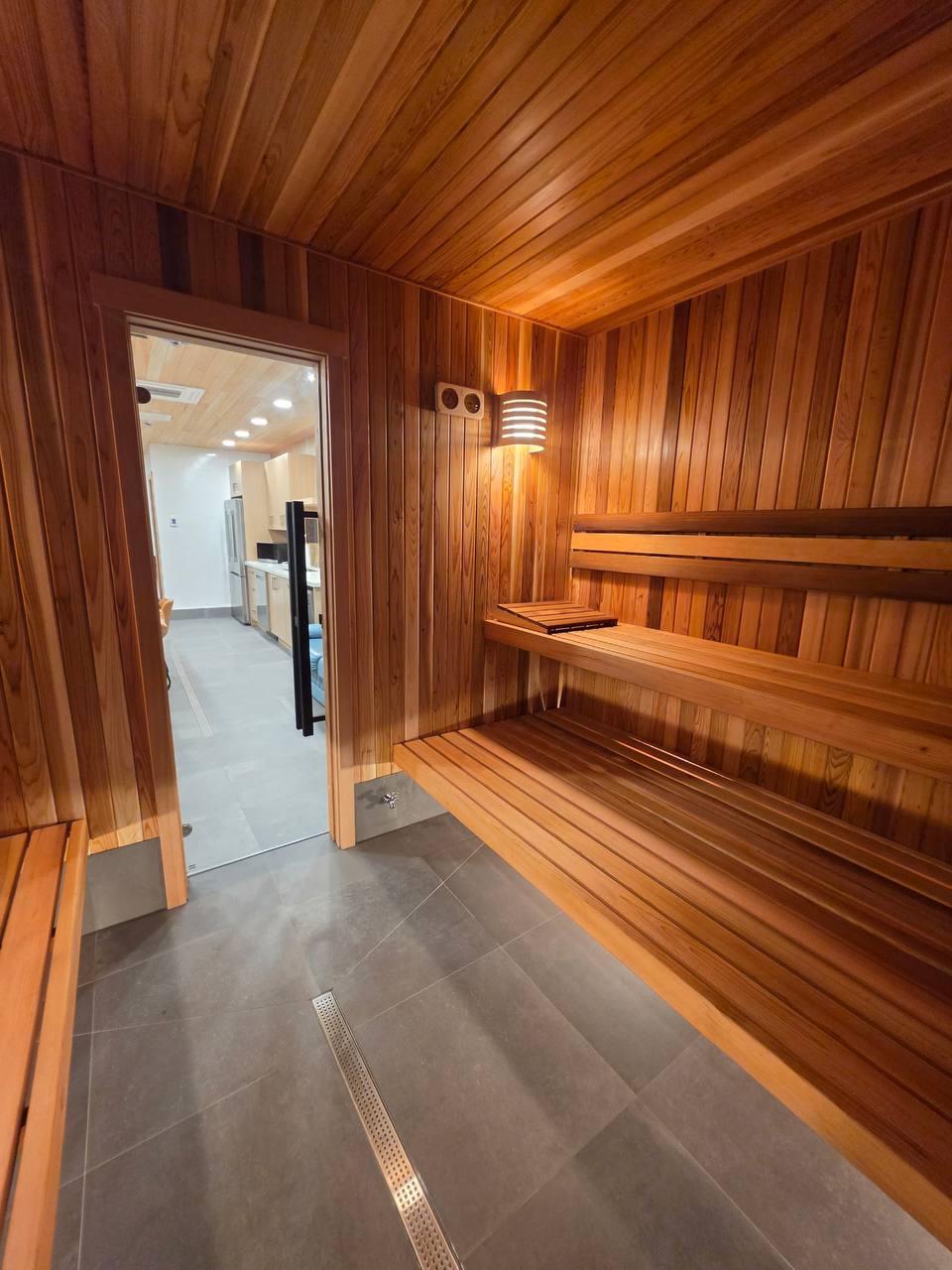 Auburn cedar sauna with benches and a warm wall light
